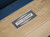 Close-up of the Paula Parsons Slate Pool Table in Glazed Maple, showcasing the smooth maple wood finish, leather drop pockets, and mother of pearl inlayed billiard sites.