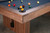 Focused angle shot of the reeded wood legs catching soft, natural light in a sun-drenched space. Great for aspirational shoppers searching “architectural pool table legs in modern home” or “refined reeded wood base pool table styled shot.”



