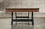 Width view of the Nixon Billiards Hunter Pool Table in Brushed Walnut, focusing on the sleek black tapered metal legs. This shot emphasizes the strong, geometric design of the legs, showcasing their bold yet refined presence as they support the beautifully crafted wood finish.

